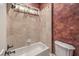 Bathroom featuring a standard bathtub and shower, and toilet with decorative wall coverings at 1477 Foothills Village Dr, Henderson, NV 89012