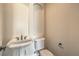 Powder room featuring pedestal sink and standard toilet with decorative trim at 1477 Foothills Village Dr, Henderson, NV 89012