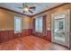 Bedroom featuring hardwood floors, wood panels, and bright windows with plantation shutters at 1477 Foothills Village Dr, Henderson, NV 89012