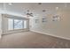 Spacious bedroom featuring carpet floors, ceiling fan, crown molding, and bright windows at 1477 Foothills Village Dr, Henderson, NV 89012