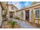 Charming courtyard featuring desert landscaping, a decorative walkway, and a stylish wrought-iron gate at 1477 Foothills Village Dr, Henderson, NV 89012