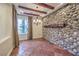 Inviting dining room featuring stone accent wall, wood beam ceiling, and stylish chandelier at 1477 Foothills Village Dr, Henderson, NV 89012