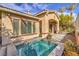 Exterior shot showing a pool with attached spa and a covered entryway at 1477 Foothills Village Dr, Henderson, NV 89012