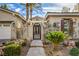 Inviting front entrance featuring an ornate iron gate, lush landscaping, and a decorative pergola at 1477 Foothills Village Dr, Henderson, NV 89012