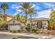 Beautiful single-story home showcasing desert landscaping, palm trees, and an inviting front entrance at 1477 Foothills Village Dr, Henderson, NV 89012