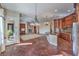 Gourmet kitchen featuring custom cabinets, a stone fireplace, and access to the backyard at 1477 Foothills Village Dr, Henderson, NV 89012