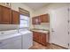 Laundry room with front loading washer/dryer, storage cabinets, countertop and wash basin at 1477 Foothills Village Dr, Henderson, NV 89012