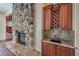 Beautiful living room featuring a stone fireplace and built-in bar with marble countertops at 1477 Foothills Village Dr, Henderson, NV 89012