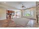 Spacious living room with stone fireplace, large windows, and terracotta tile flooring at 1477 Foothills Village Dr, Henderson, NV 89012