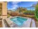 Backyard pool with an elevated spa, with a view of the neighborhood landscape and blue sky at 1477 Foothills Village Dr, Henderson, NV 89012