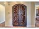 Elaborate wrought iron doors with ornate vine detailing, leading to the wine room at 1477 Foothills Village Dr, Henderson, NV 89012