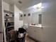 Modest bathroom with a single sink vanity, toilet, mirror, and cluttered shelving at 2101 Sun Ave, North Las Vegas, NV 89030