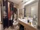 Bathroom with single sink vanity, shower/tub combo, and mirrored wall at 2101 Sun Ave, North Las Vegas, NV 89030