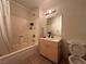 Bathroom with tiled tub, vanity with a mirror and lighting, and a toilet at 2101 Sun Ave, North Las Vegas, NV 89030