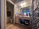 Modest bathroom with essential fixtures and adjacent storage shelving at 2101 Sun Ave, North Las Vegas, NV 89030
