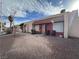 Charming single-story townhome with red facade and tile roof with small front yard with chairs at 2101 Sun Ave, North Las Vegas, NV 89030