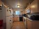 Compact kitchen featuring tile flooring, wood cabinets, and standard appliances at 2101 Sun Ave, North Las Vegas, NV 89030