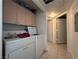 Laundry room with washer, dryer, tile floor, and storage cabinets at 2101 Sun Ave, North Las Vegas, NV 89030