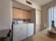 A compact laundry area with functional washer/dryer and cabinets for storage, conveniently located near the dining area at 2101 Sun Ave, North Las Vegas, NV 89030
