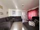 Inviting living room featuring a large sectional sofa, tiled floors, and a door at 2101 Sun Ave, North Las Vegas, NV 89030