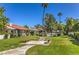 Landscaped common area with manicured lawn, benches, and mature trees and shrubs around the community pool at 2579 La Fortuna Ave, Las Vegas, NV 89121