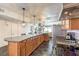 Large kitchen featuring wooden cabinetry, stainless steel appliances, an extended island, and views of the living area at 2579 La Fortuna Ave, Las Vegas, NV 89121