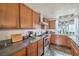 Kitchen with wood cabinets, stainless steel appliances, a modern hood vent, and a window providing natural light at 2579 La Fortuna Ave, Las Vegas, NV 89121