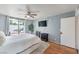 Well-lit bedroom showcasing a king bed, slider to patio, a ceiling fan, and hardwood floors at 2579 La Fortuna Ave, Las Vegas, NV 89121