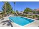 Sparkling community pool with well-maintained landscaping, lounge chairs, and clear blue skies at 2579 La Fortuna Ave, Las Vegas, NV 89121