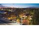 Aerial view of a home with a large circular driveway, manicured lawns and vibrant city lights at 2818 E Quail Ave, Las Vegas, NV 89120