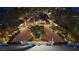 Night aerial view highlights the property's illuminated landscaping, circular driveway, and expansive layout at 2818 E Quail Ave, Las Vegas, NV 89120