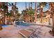 Inviting backyard with lounge chairs by the pool, tropical landscaping, and exterior string lights at 2818 E Quail Ave, Las Vegas, NV 89120