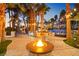 Backyard with a fire pit, outdoor seating, and palm trees at dusk at 2818 E Quail Ave, Las Vegas, NV 89120