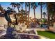 Backyard with a unique statue, cabana, pool, and plenty of palm trees at 2818 E Quail Ave, Las Vegas, NV 89120