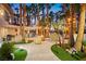 Landscaped backyard with a built-in bar, exterior string lights, and lush tropical plants at 2818 E Quail Ave, Las Vegas, NV 89120