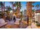 Cozy outdoor seating on a private balcony overlooking tropical landscaping and a swimming pool at 2818 E Quail Ave, Las Vegas, NV 89120