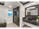 Modern bathroom featuring dark granite counters, unique basin sink and a glass enclosed shower at 2818 E Quail Ave, Las Vegas, NV 89120