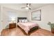 Well-lit bedroom features a comfortable bed with a pink cover, modern fan, and attractive artwork at 2818 E Quail Ave, Las Vegas, NV 89120