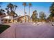 Expansive driveway leading to a luxurious home surrounded by palm trees and lush landscaping at 2818 E Quail Ave, Las Vegas, NV 89120