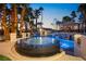 Stunning backyard with a pool, hot tub, and cabana at dusk at 2818 E Quail Ave, Las Vegas, NV 89120
