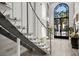 Elegant staircase with marble steps and glass railing leads to a sunlit entryway with ornate ironwork doors at 2818 E Quail Ave, Las Vegas, NV 89120