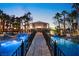 Stunning swimming pool with bridge, lounge area and lush tropical landscaping at dusk at 2818 E Quail Ave, Las Vegas, NV 89120