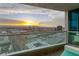 Balcony view with comfortable seating showcases a golden sunset over Las Vegas and distant mountains at 4525 Dean Martin Dr # 2800, Las Vegas, NV 89103