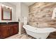 Bathroom featuring a free standing tub and wood look tile accent wall at 4525 Dean Martin Dr # 2800, Las Vegas, NV 89103