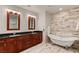 Bathroom featuring a double vanity, free standing tub, and wood look tile accent wall at 4525 Dean Martin Dr # 2800, Las Vegas, NV 89103