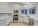 Bright kitchen features white cabinets, stainless steel appliances, and modern countertops at 612 Bullwhip Ct, Henderson, NV 89011