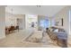 Open-concept floor plan with gray sofa and dining area, flowing into a white kitchen at 612 Bullwhip Ct, Henderson, NV 89011