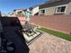 Backyard features a brick fence, paver patio, and outdoor dining furniture under an umbrella at 7068 Parrot Bay Way, Las Vegas, NV 89118