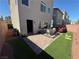 Inviting backyard featuring a paver patio, artificial turf, and a cozy dining area at 7068 Parrot Bay Way, Las Vegas, NV 89118