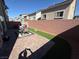 Backyard features a brick fence, paver patio, and outdoor dining furniture under an umbrella at 7068 Parrot Bay Way, Las Vegas, NV 89118